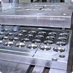 Presse hydraulique industrielle appliquant chaleur et pression à une pièce de plastique thermodurcissable injectée dans un moule.