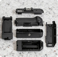 Multi-material part featuring a soft-touch rubber overmold on a rigid plastic substrate.