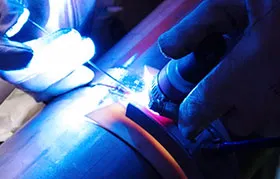An intense close-up of the bright arc during a TIG welding (GTAW) operation, showing the tungsten electrode and filler rod at the point of fusion on a metal pipe.