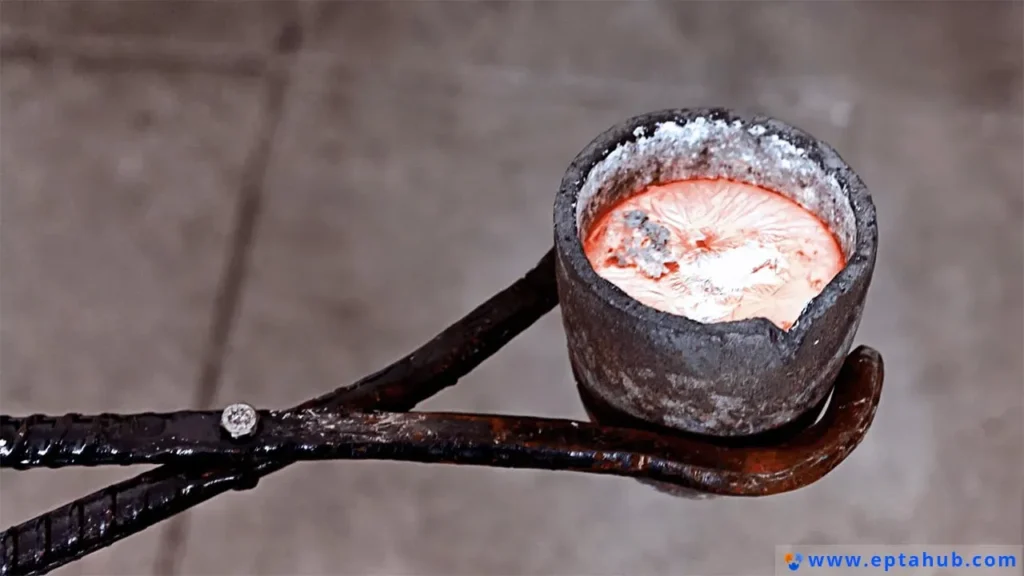 Industrial tongs securely holding a foundry crucible filled with glowing, liquid molten aluminum, illustrating the high-temperature casting process in a manufacturing environment which requires precise temperature control around the melting point.