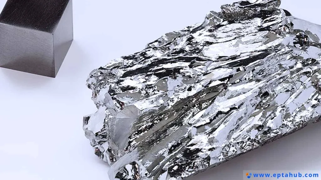 Ein Stück rohes, kristallines Chrommetall neben einem präzisionsgefertigten Würfel veranschaulicht das wichtigste Legierungselement, das allen Edelstählen ihre Korrosionsbeständigkeit verleiht.