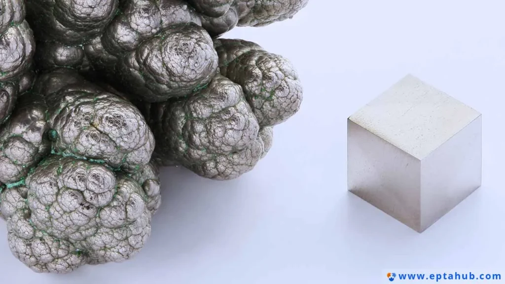 Ein Vergleich zeigt eine Ansammlung von rohem, traubenförmigem Nickel, einem wichtigen Legierungselement in Edelstahl, neben einem perfekt bearbeiteten Metallwürfel, der das fertige, technische Produkt darstellt.