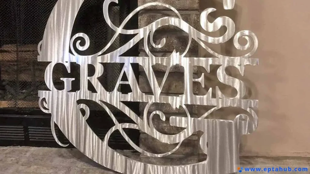 A personalized, decorative metal sign with the name 'GRAVES' surrounded by elegant swirls, featuring a beautiful brushed finish. An example of custom art made by laser or plasma cutting.