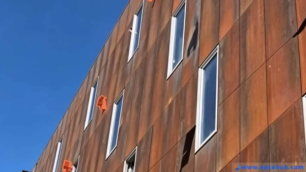 The facade of a modern building clad in Corten steel panels, showcasing the material's distinctive, stable rust-like patina, a popular option for durable and stylish architectural signs and siding.