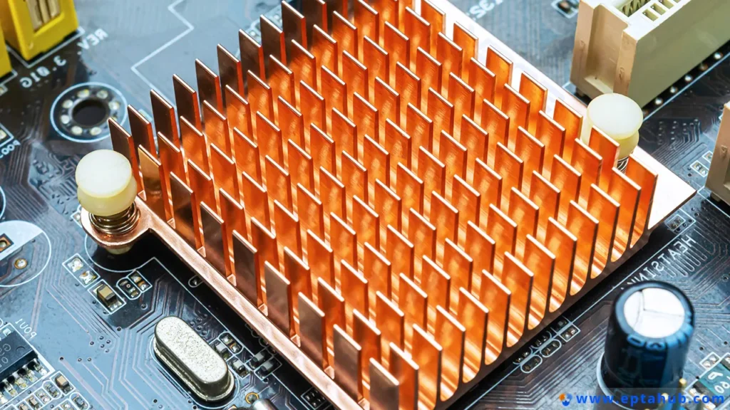 A close-up of a high-performance, custom machined copper heat sink mounted on a computer motherboard to cool a critical chipset, showcasing the precision fins required for maximum surface area.