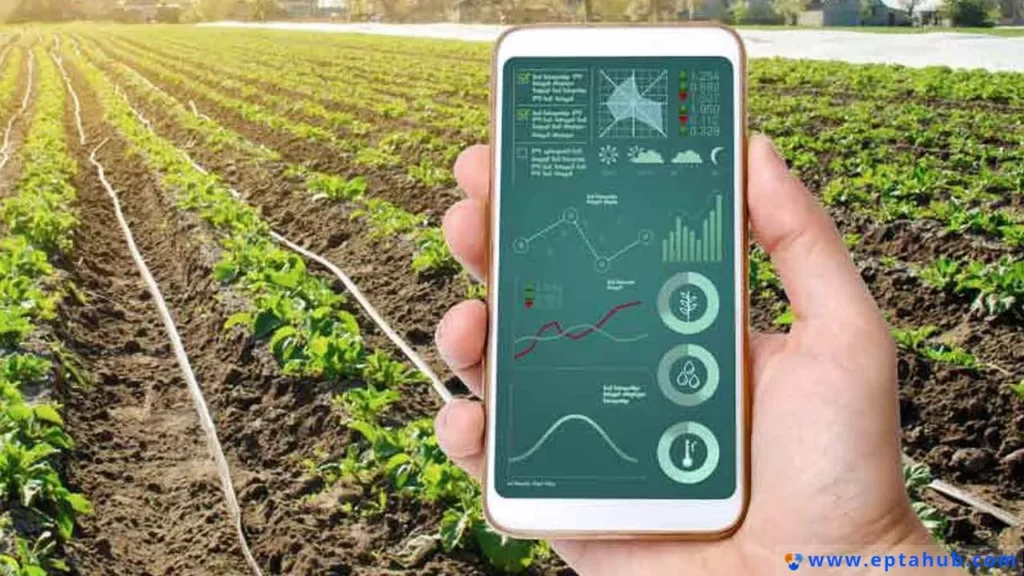 A hand holding a smartphone displaying smart agriculture data over a field, illustrating how modern IoT devices require thermal management solutions like compact heat sinks to function reliably.